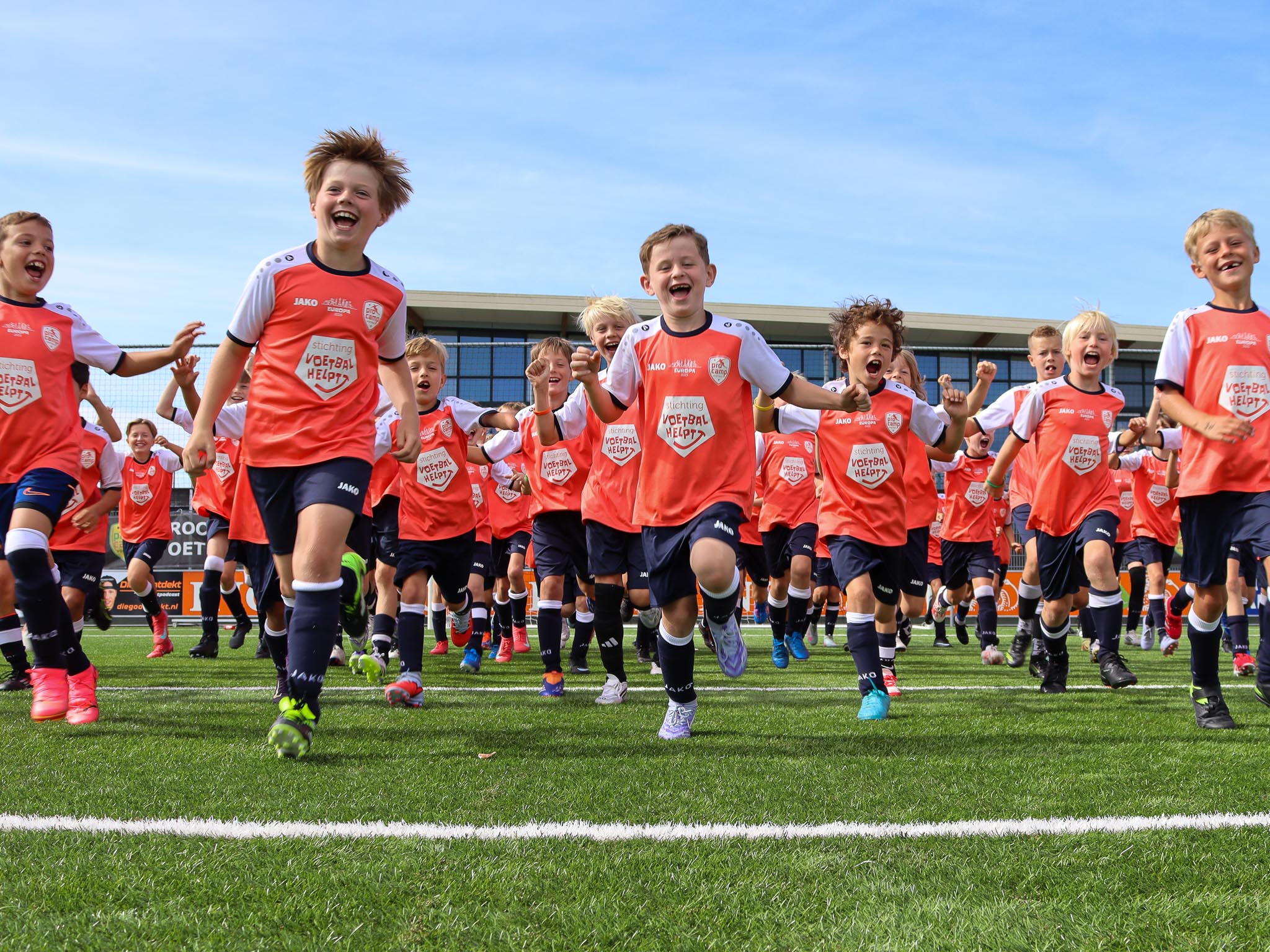 Rennende kinderen op veld ProCamp voetbalkamp